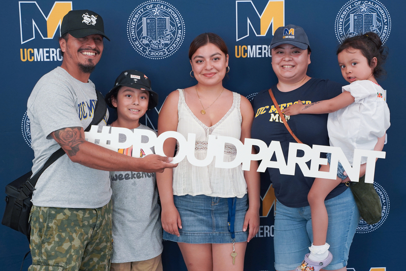 Newly admitted Bobcat and family post for photo celebrating their admission to UC Merced.